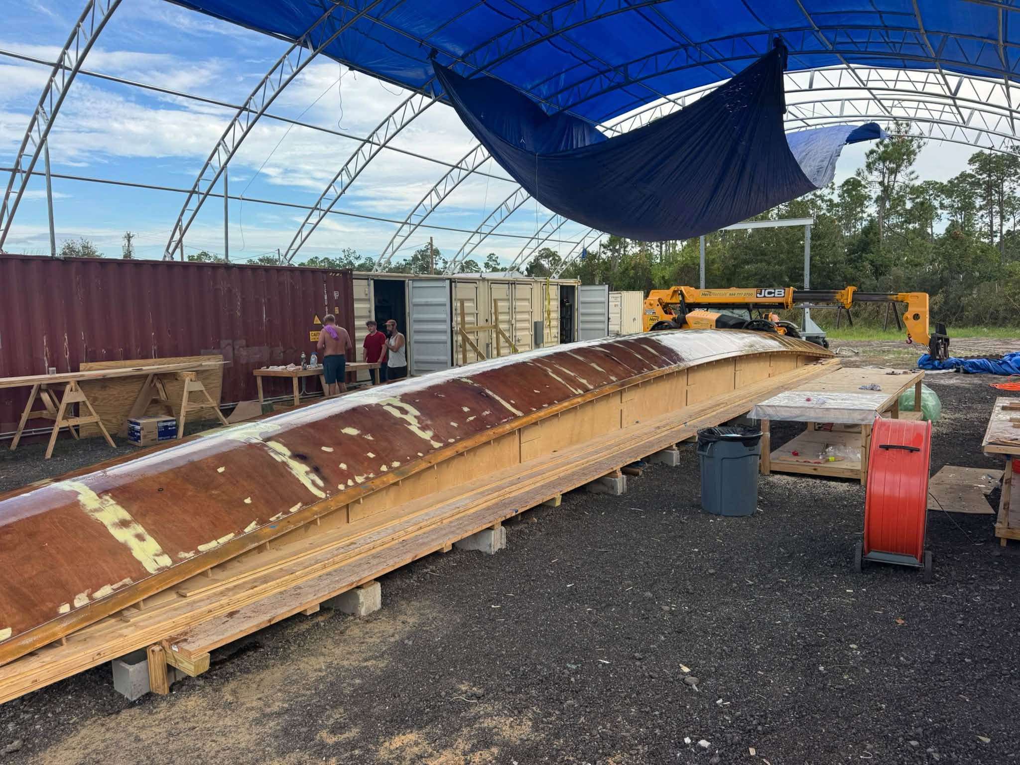 The finished hull mold, faired and sealed, under the tent at the yard