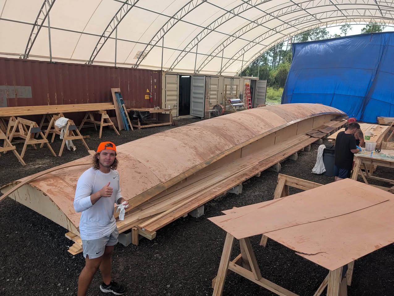 The hull mold taking shape under the tent, with the crew at work